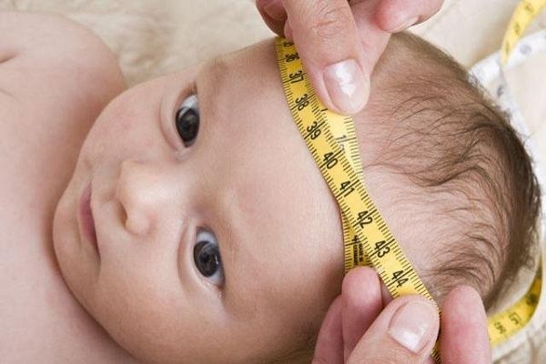Bác sĩ đo kích thước cỡ đầu để kiểm tra thóp trước trẻ sơ sinh