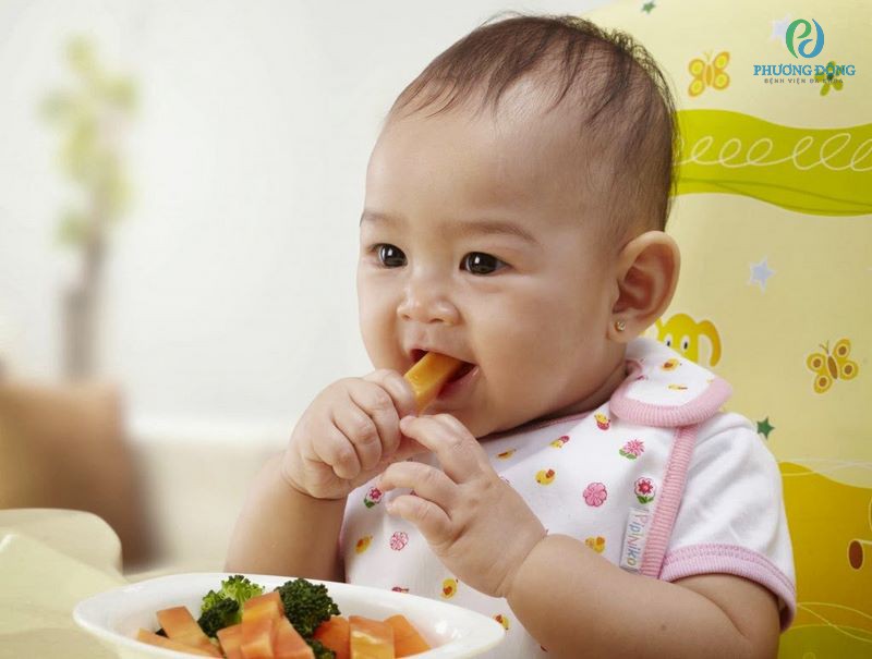 Bé 10 tháng tuổi có thể cầm nắm thức ăn và đưa vào miệng