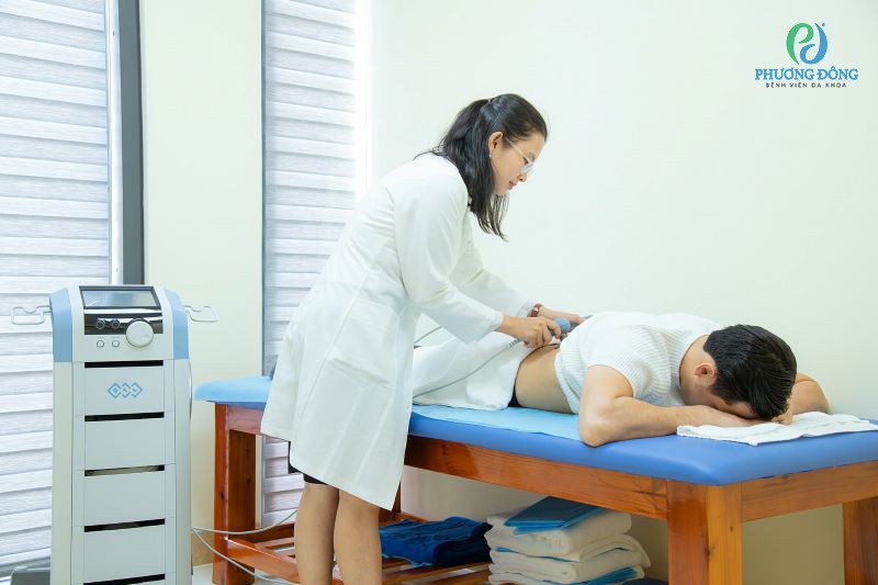 Bác sĩ đang tiến hành điều trị vật lí trị liệu cho bệnh nhân đau lưng