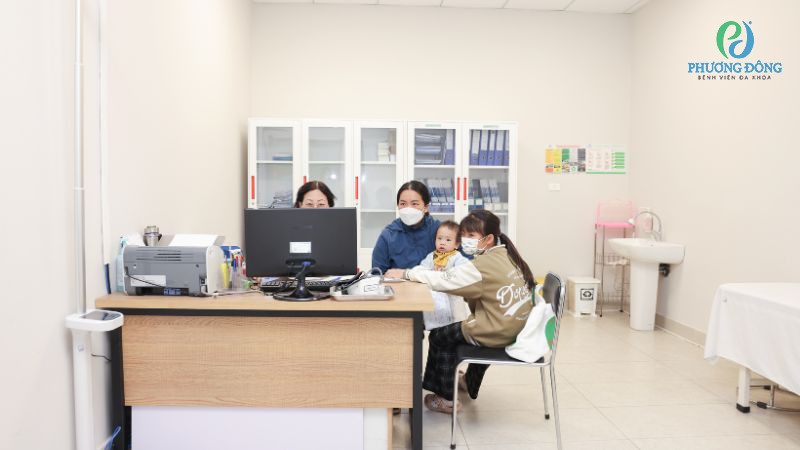 Phụ huynh nên phối hợp với nhân viên y tế trong lúc nhỏ vaccine rota vào miệng trẻ