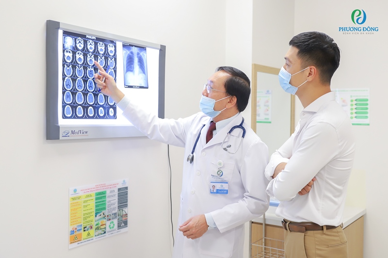 Hình ảnh bác sĩ phân tích phim chụp X-quang não bộ và phổi của người bệnh