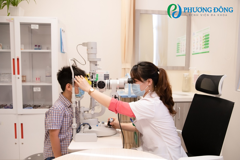 Bác sĩ đang thăm khám mắt cho bé bằng sinh hiển vi