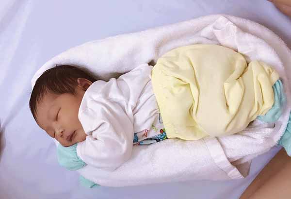 Cách quấn khăn thành tổ giúp hạn chế tình trạng ngủ giật mình ở trẻ sơ sinh.
