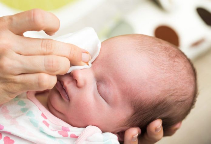 Why does a newborn baby have green discharge in one eye?