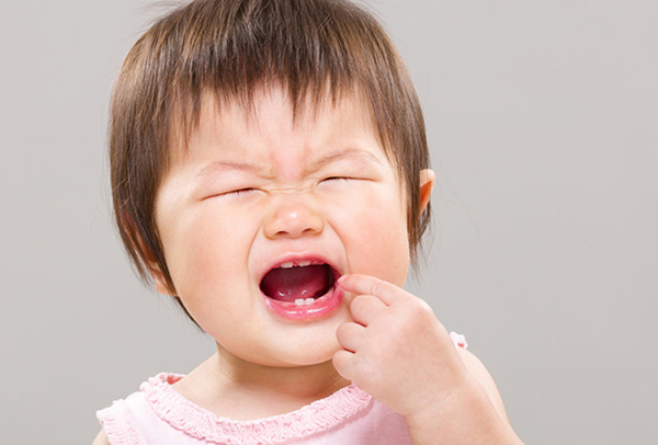 Mọc răng khiến nướu sưng đau nên trẻ ngủ không ngon và quấy khóc về đêm